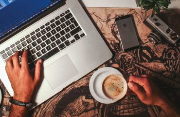 Coffee on a desk by a laptop and phone