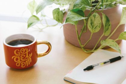 Notepad-and-Coffee with a plant on a table