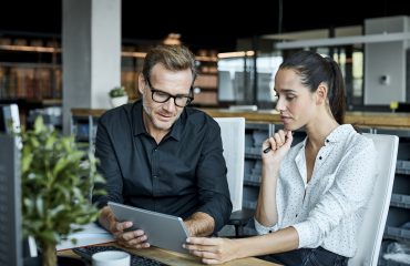 Two colleagues talking while scrolling through their ipad