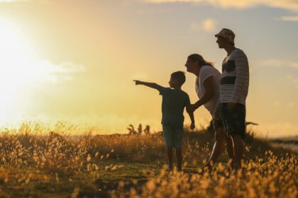 Family overlooking a field during a sunset