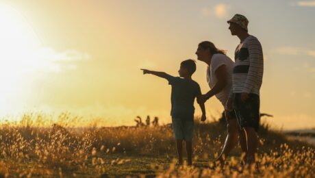Family overlooking a field during a sunset
