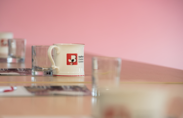 Staffordshire Chambers mug sat on a desk with other glasses for a meeting