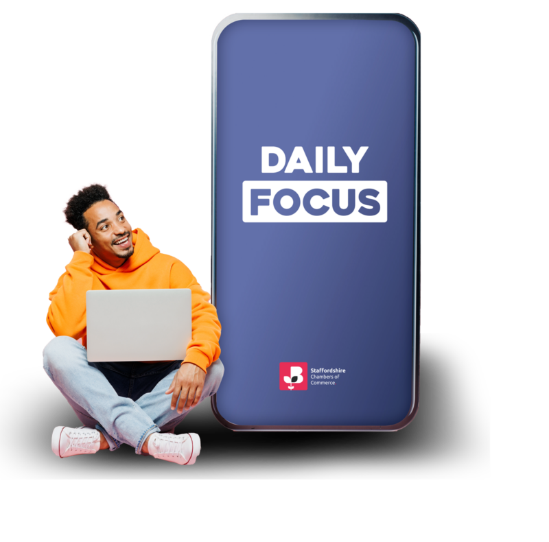 Picture of a person looking at a big phone with the daily focus logo on it with Staffordshire chambers of commerce logo as well.