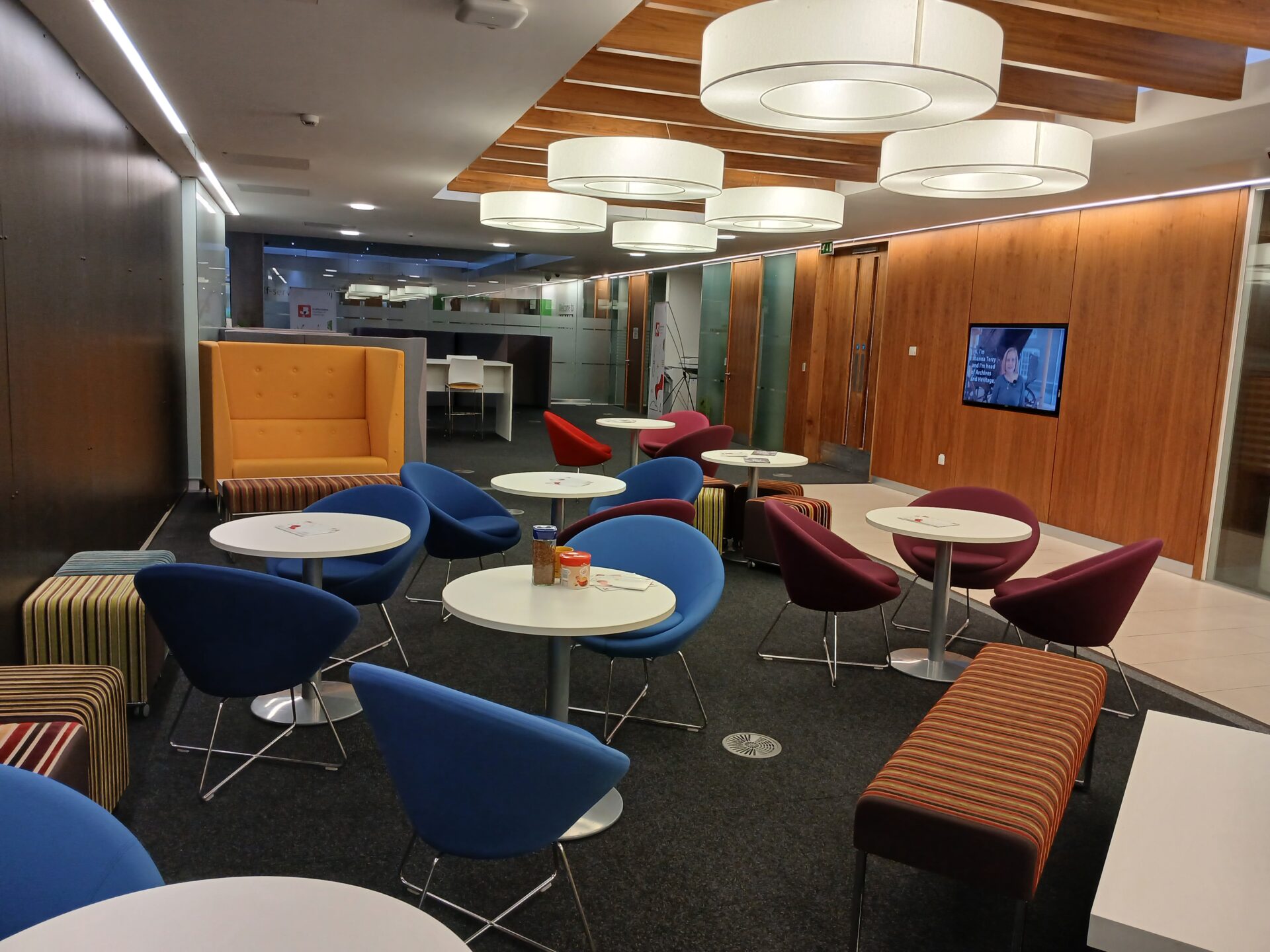 Stafford Chamber Members Lounge with a number of tables and chairs with a TV on the wall