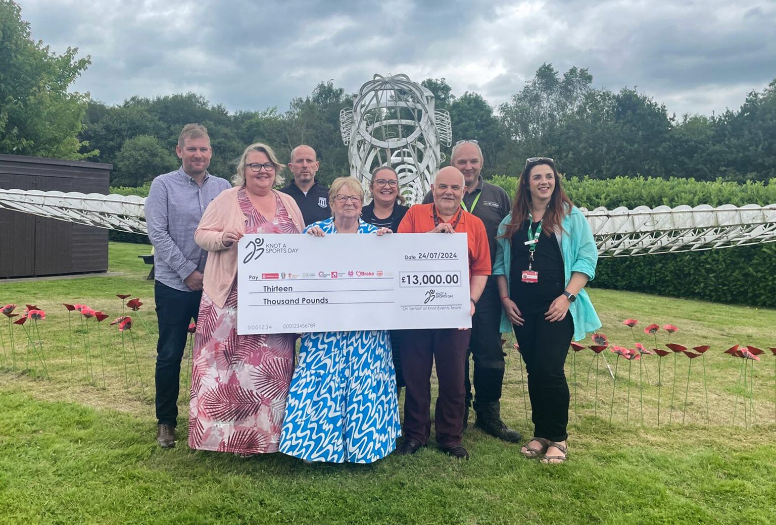 Knot a Sports Day organisers holding a cheque for £13,000